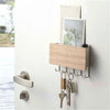 A light wood bamboo wall-mounted key rack with six hooks displayed on a white wall.