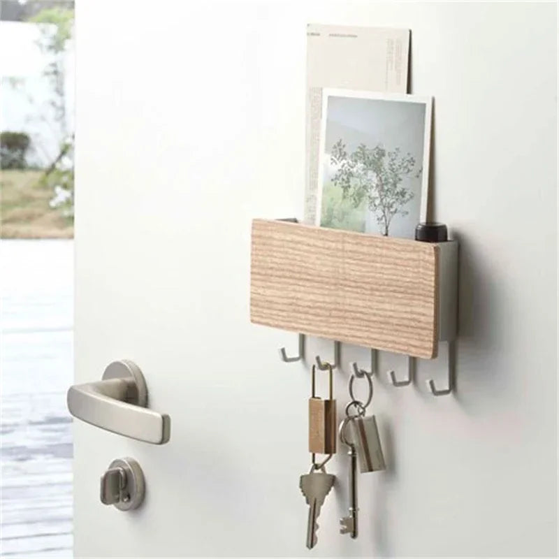 A light wood bamboo wall-mounted key rack with six hooks displayed on a white wall.