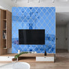 A modern living room featuring a large flat-screen TV mounted on a blue diamond patterned mirror wall.