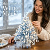 A woman is assembling a sparkling DIY winter tree kit featuring blue and white crystals and beads.