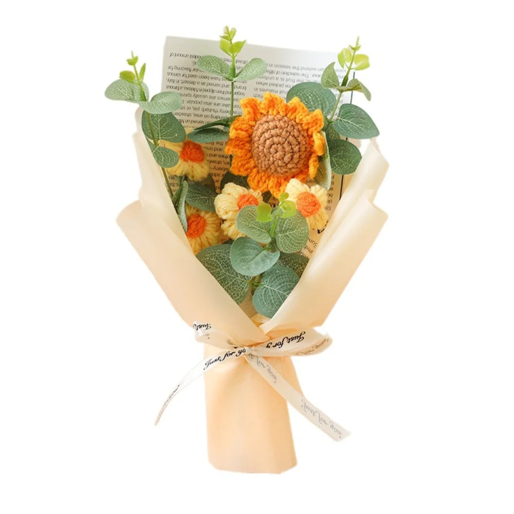 A handmade sunflower daisy crochet bouquet with green leaves wrapped in light beige paper.