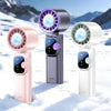 Three versions of a handheld fan with purple, pink, and green blades are displayed in a snowy outdoor setting.