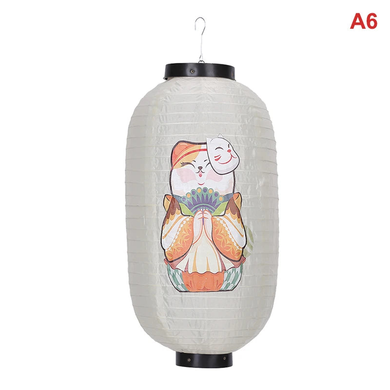 A white paper hanging lantern with a smiling face design, suspended by a black hook.