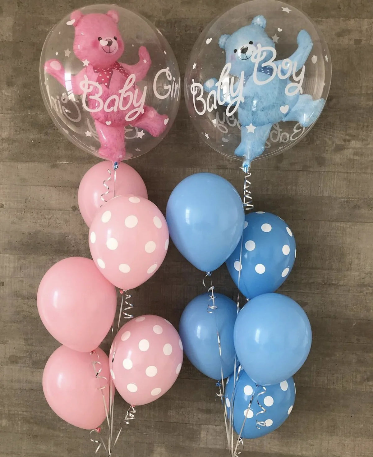 A collection of foil balloons featuring a pink bear and a blue bear boy, along with solid light blue and pink balloons.