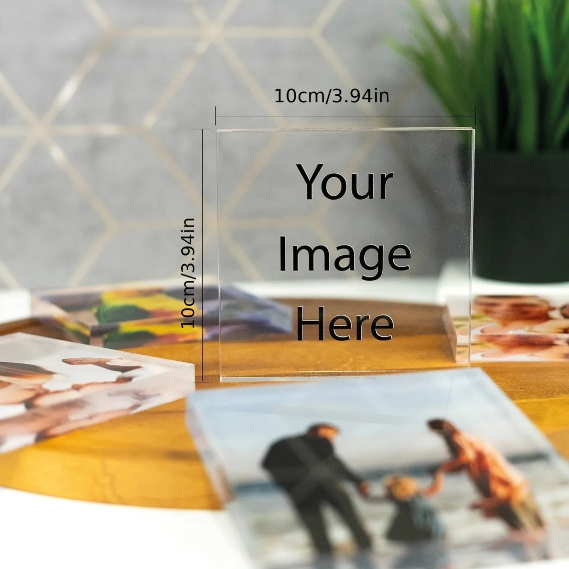 A clear acrylic photo ornament with custom text engraved on it, displayed on a wooden surface.