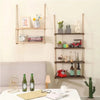 A rustic floating wooden storage shelf mounted on a wall displaying various decorative items and books.