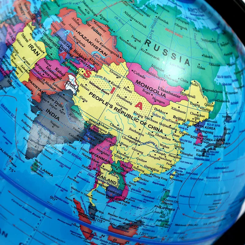 A close-up view of a desktop educational globe showing the world map with political boundaries and oceans.