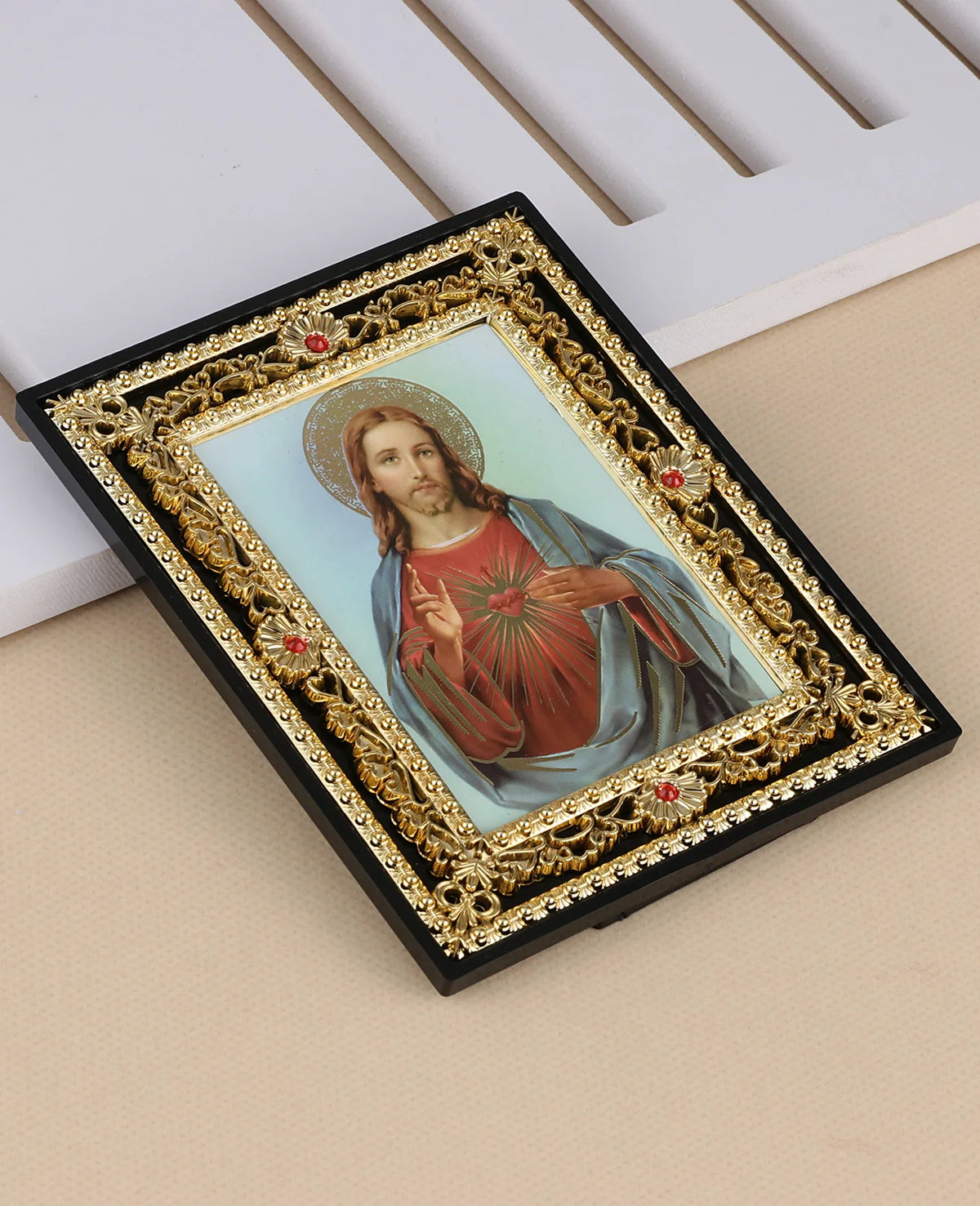 A framed religious icon depicting Jesus Christ with a halo and St. Michael, set in a black frame with gold accents.