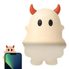 A white ghost phone decoration charm is shown next to a smartphone.
