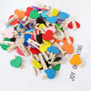 A collection of colorful mini wooden photo clips shaped like hearts scattered on a white background.