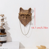 A bronze deer head storage hook wall decor with a chain hanging below it.