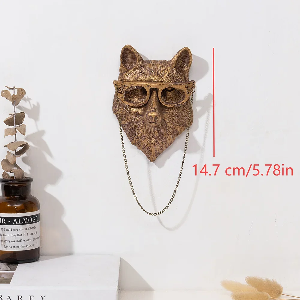 A bronze deer head storage hook wall decor with a chain hanging below it.