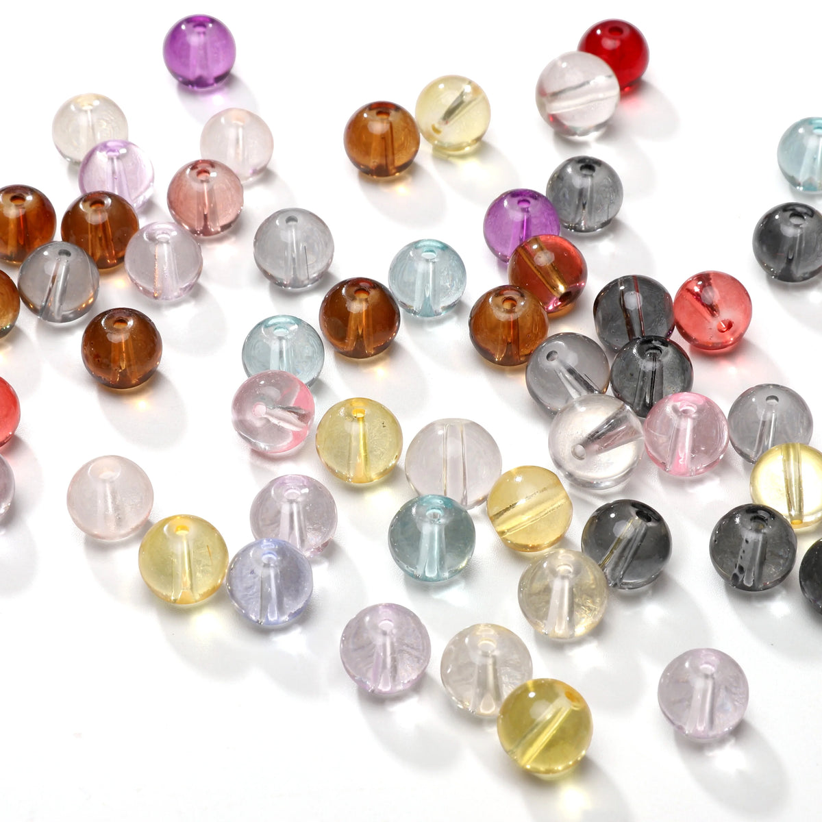 A collection of round glass spacer beads in various colors including purple, pink, amber, and clear shades.