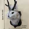 A decorative bunny head with gray fur and black antlers mounted on a wall.