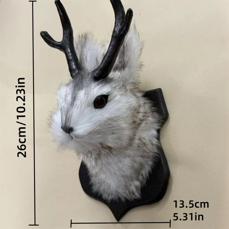 A decorative bunny head with gray fur and black antlers mounted on a wall.