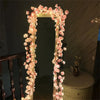 A tall mirror framed by pink floral LED rattan string lights for seasonal decor