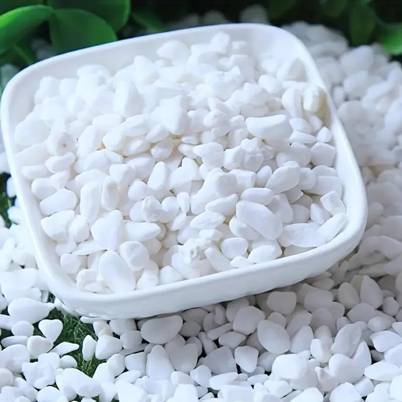 A white bowl filled with natural polished white pebble stones for aquariums and planters.