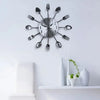 A modern cutlery 3D wall clock with a silver fork design mounted on a white wall.