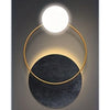 Modern geometric canvas wall art featuring a gold ring light illuminating a round white bulb above a dark circular base.