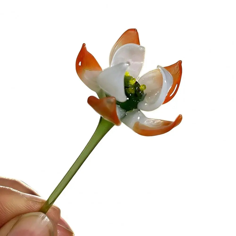 Handcrafted blue glass flower sculpture with orange and white petals on a green stem