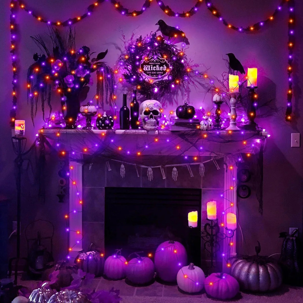 A fireplace decorated with purple and orange LED string lights, pumpkins, and spooky foliage for Halloween.