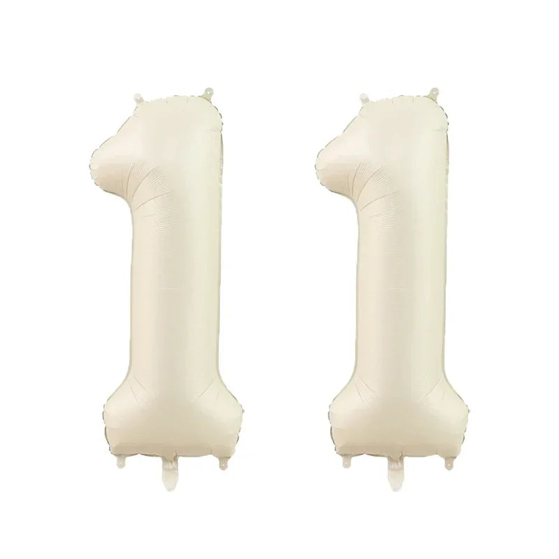 Two beige helium foil number balloons shaped like the number one
