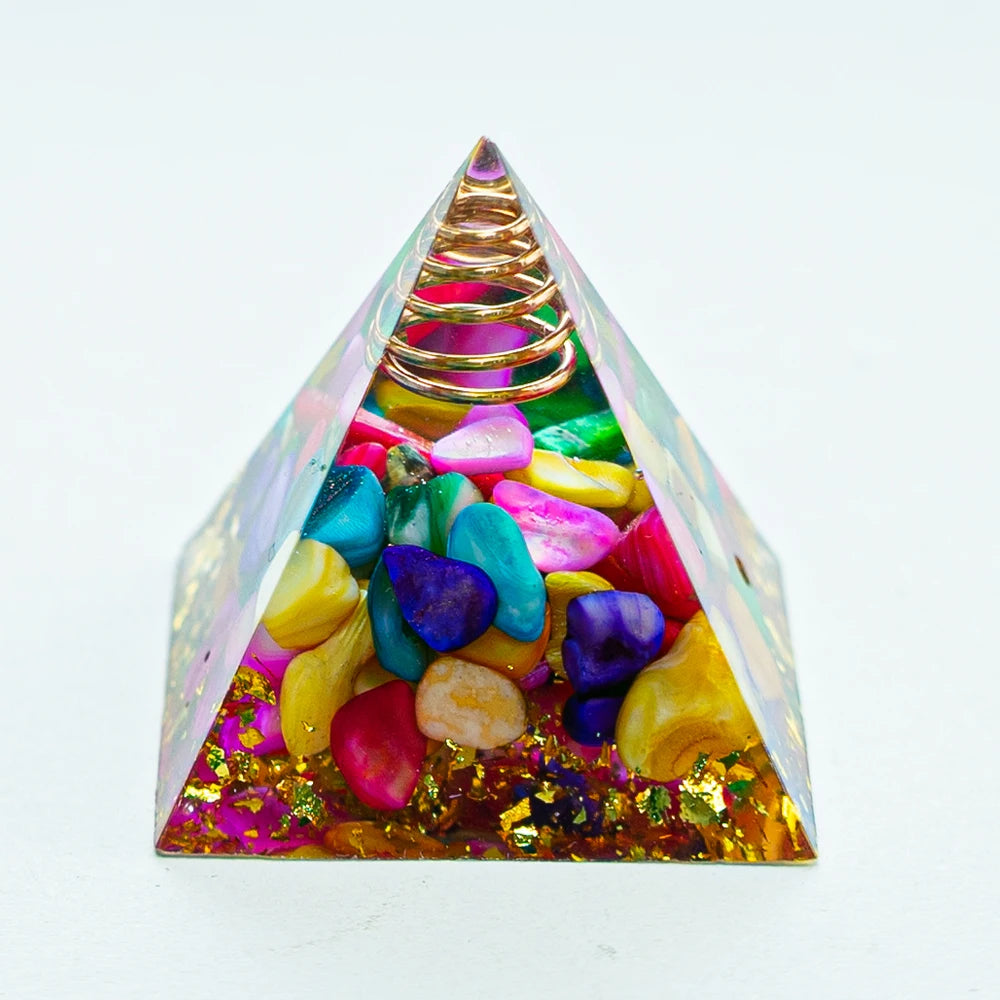 A pyramid structure made of various colored crystals, including amethyst and quartz, with a gold coil at the apex.