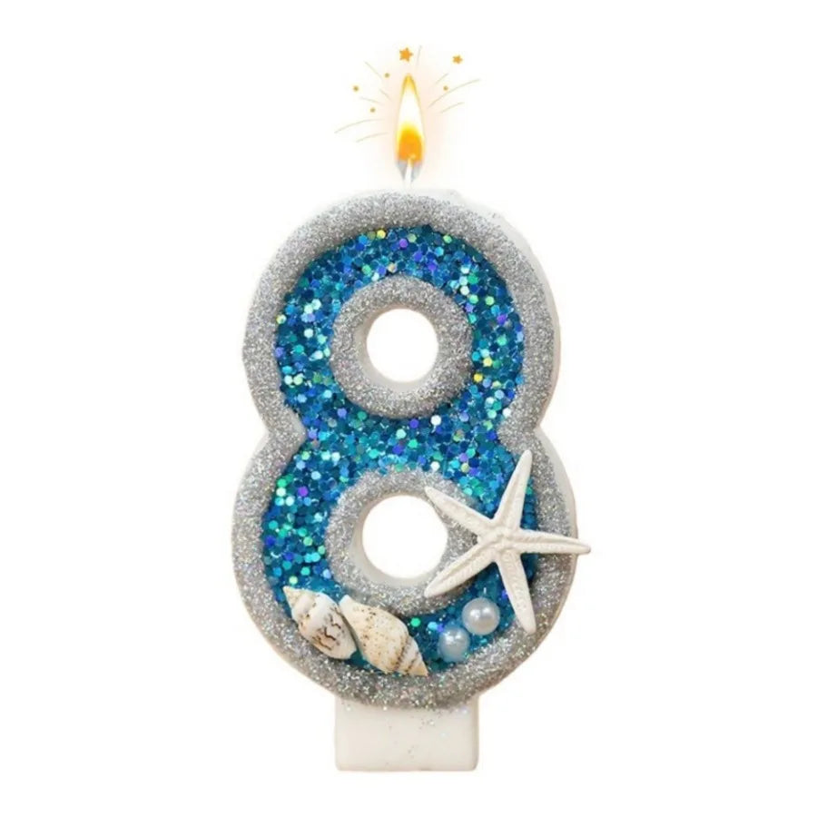A silver glitter number eight candle with blue iridescent glitter and a starfish decoration.