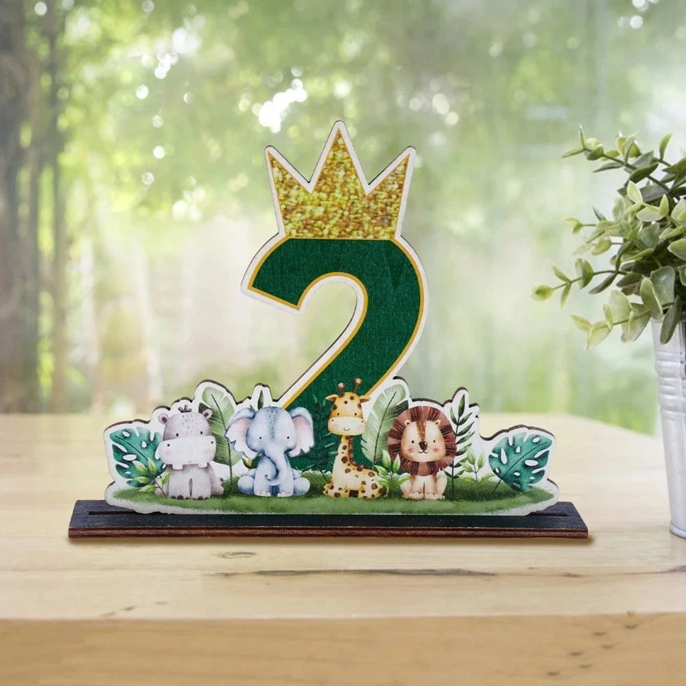 A green wooden ornament shaped like the number 2, decorated with jungle animals and a gold crown.