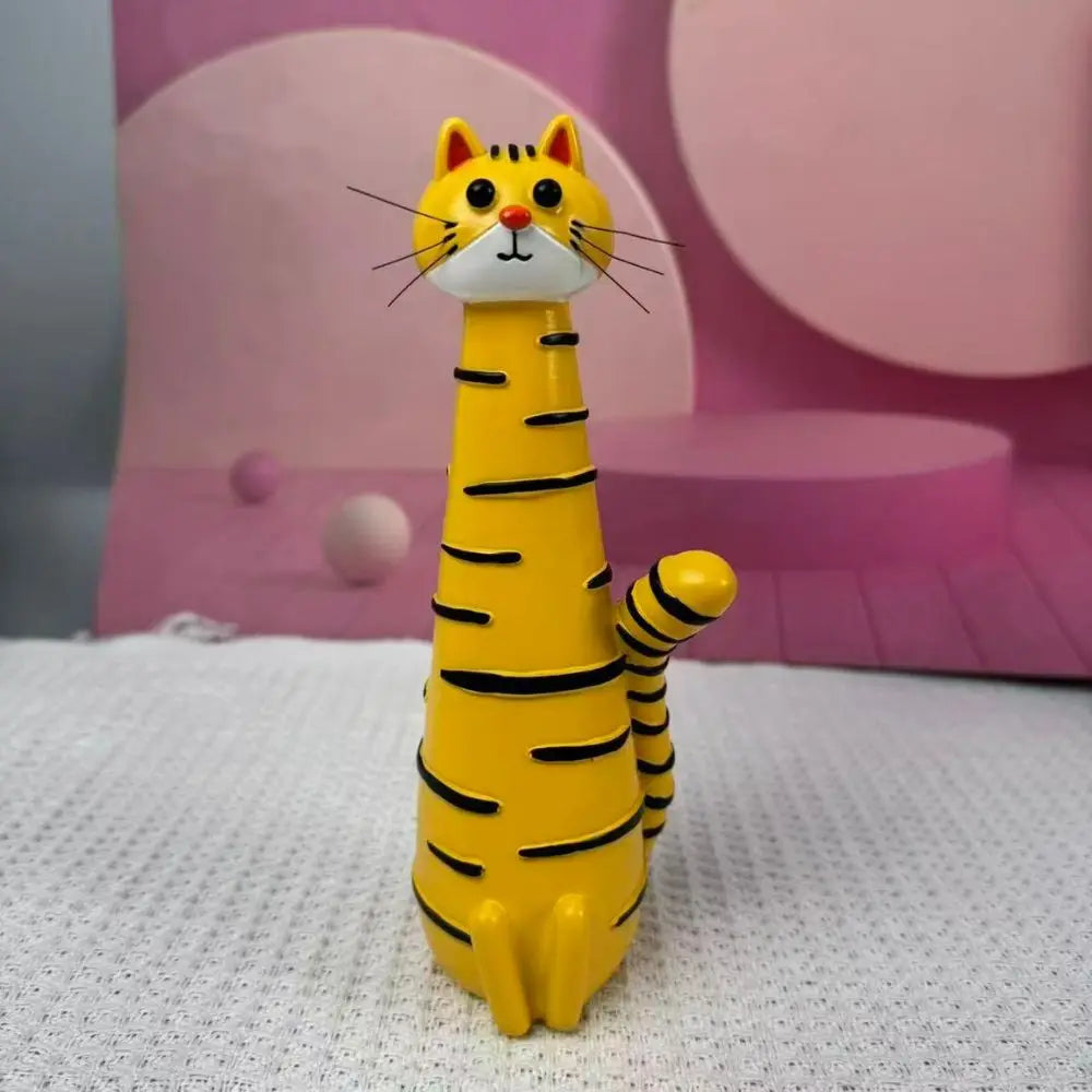 A yellow cat-shaped resin vase with black stripes is displayed against a pink background.
