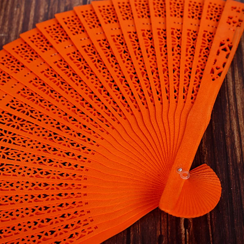 Orange hand carved bamboo folding fan with intricate lattice patterns