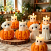 A collection of silicone candle molds featuring cute ghost, cat, dog, and pumpkin designs, some lit with candles.