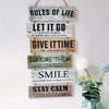 A vertical display of wooden inspirational signs with text like Rules of Life Let It Go Give It Time Ignore Them Smile and St