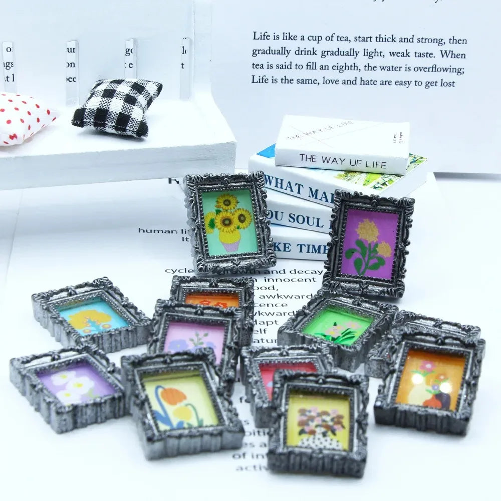 A collection of miniature framed wall art pieces with various floral and nature designs displayed on a white surface.