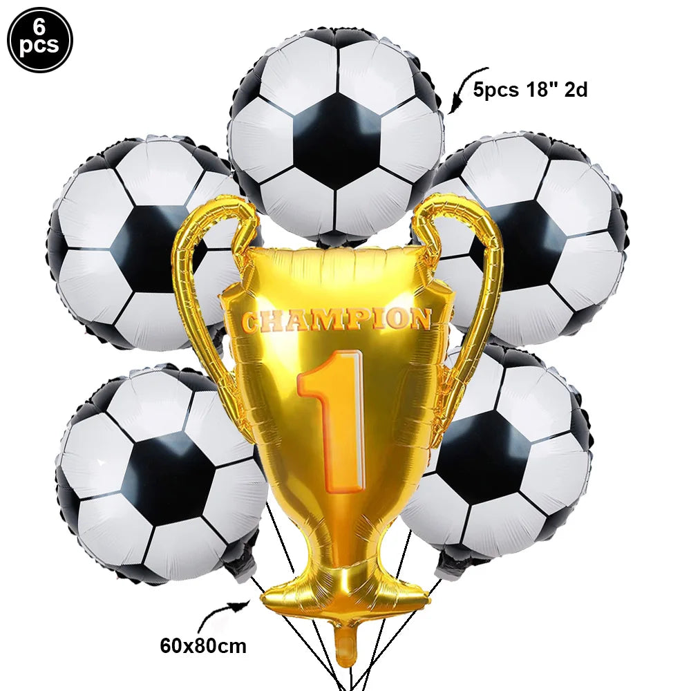 A gold trophy balloon with the number 1 is surrounded by black and white soccer balls for a party decoration.