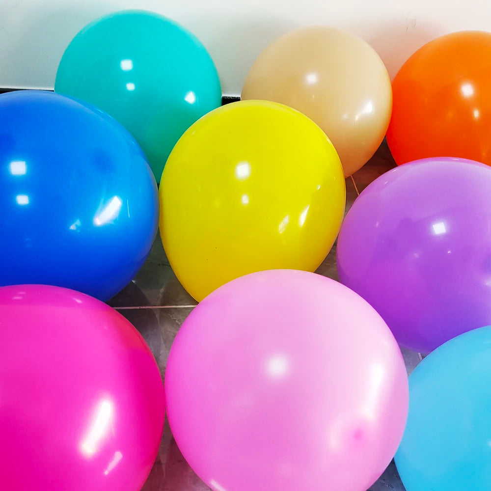 A collection of matte latex balloons in various colors including blue, yellow, orange, pink, and purple.