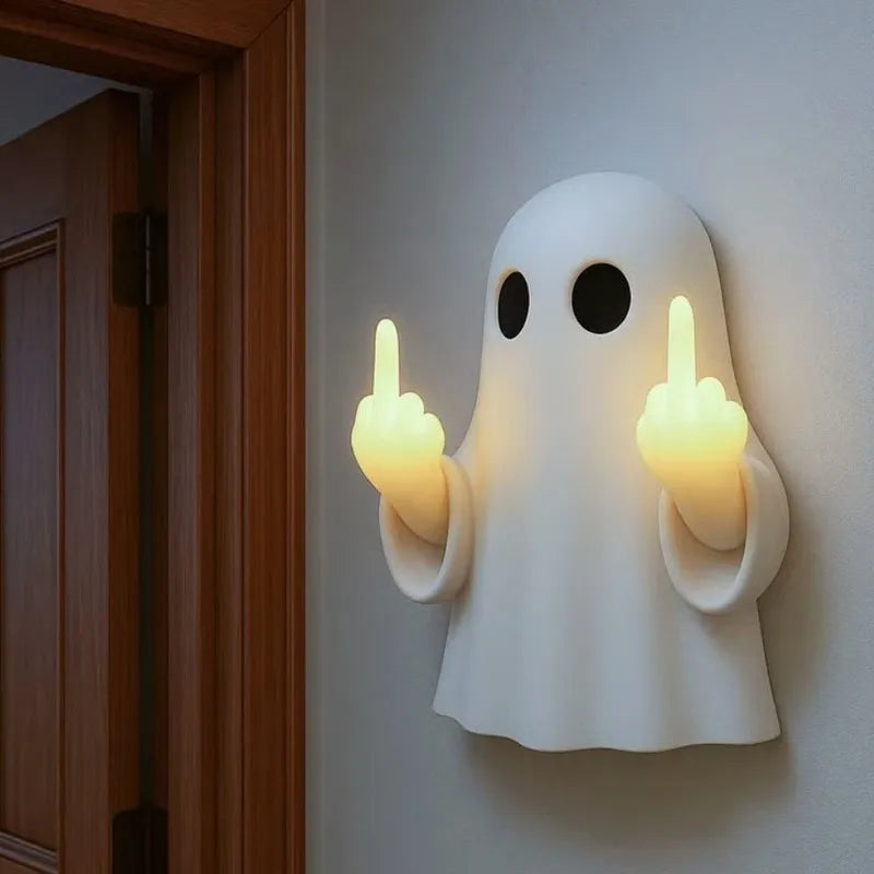 A white ghost figurine lamp with a warm glow is mounted on a wall next to a wooden door frame.