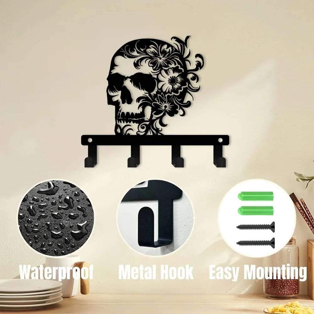 A black iron skull wall hook with floral accents mounted on a light-colored wall.