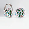 Silver handbag hook with a round floral crystal design featuring pink, green, and blue flowers