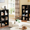 A black wooden storage organizer bookcase with open shelves and various decorative items in a bright room.