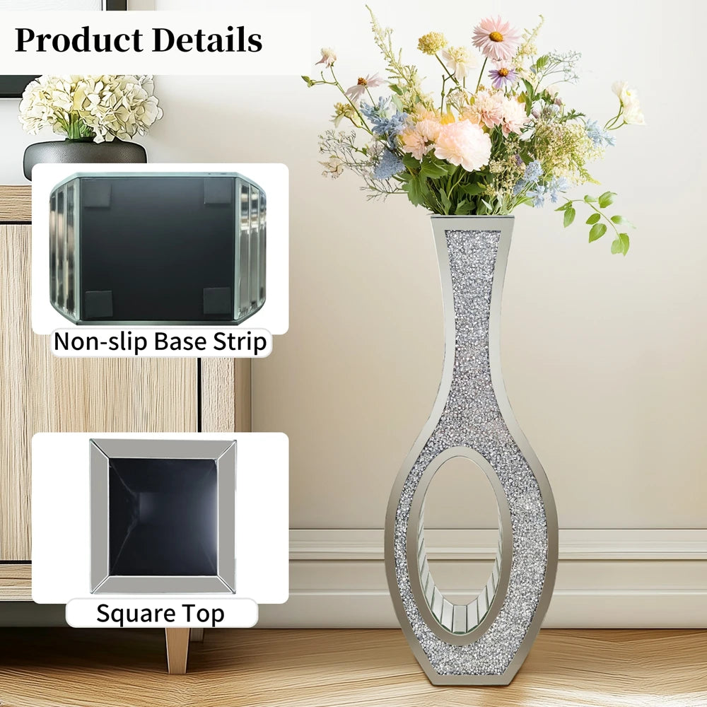 Tall silver mirrored vase with a crushed diamond finish displayed next to floral arrangements.