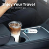 A clear plastic cup with a lid containing iced coffee is placed in a car cup holder.
