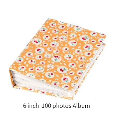 A 6 inch 100 photos album with an orange floral pattern cover and white pages.