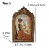 A vintage resin rotating photo frame with an ornate gold frame displaying a portrait.