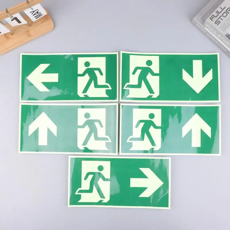A set of five photoluminescent emergency exit sign decals showing various directional arrows.