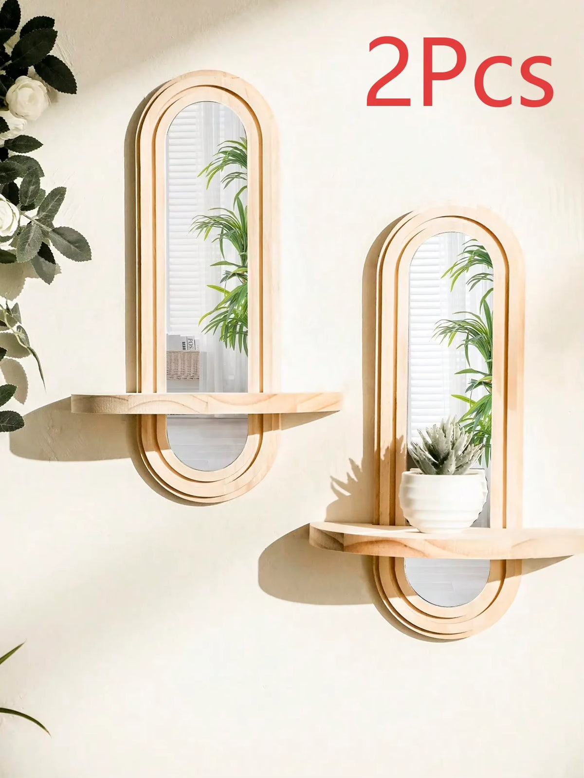 Two wooden geometric wall shelves with oval mirrors and vertical plant accents mounted on a light-colored wall.