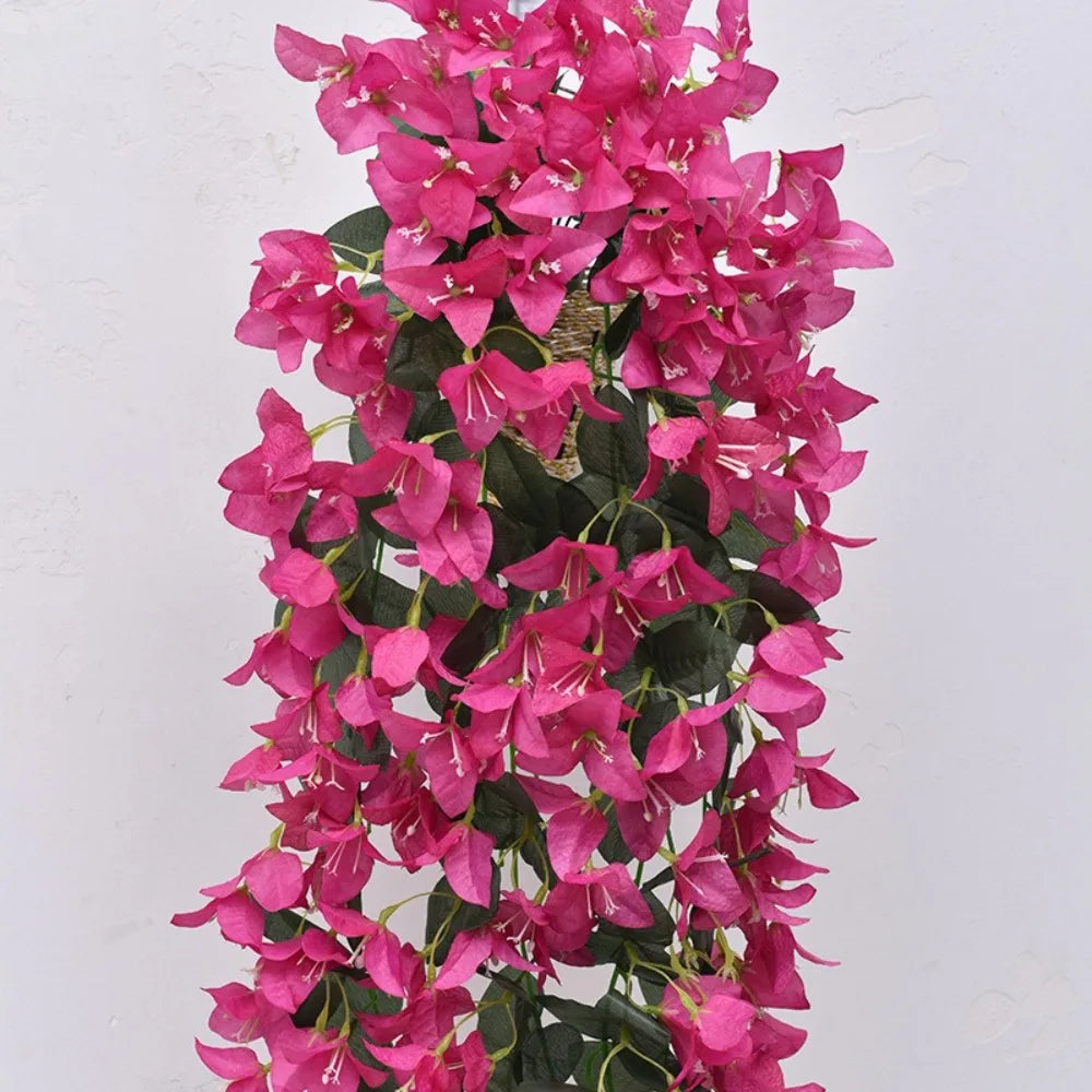 A vibrant pink faux bougainvillea vine cascading down, featuring numerous small flowers.