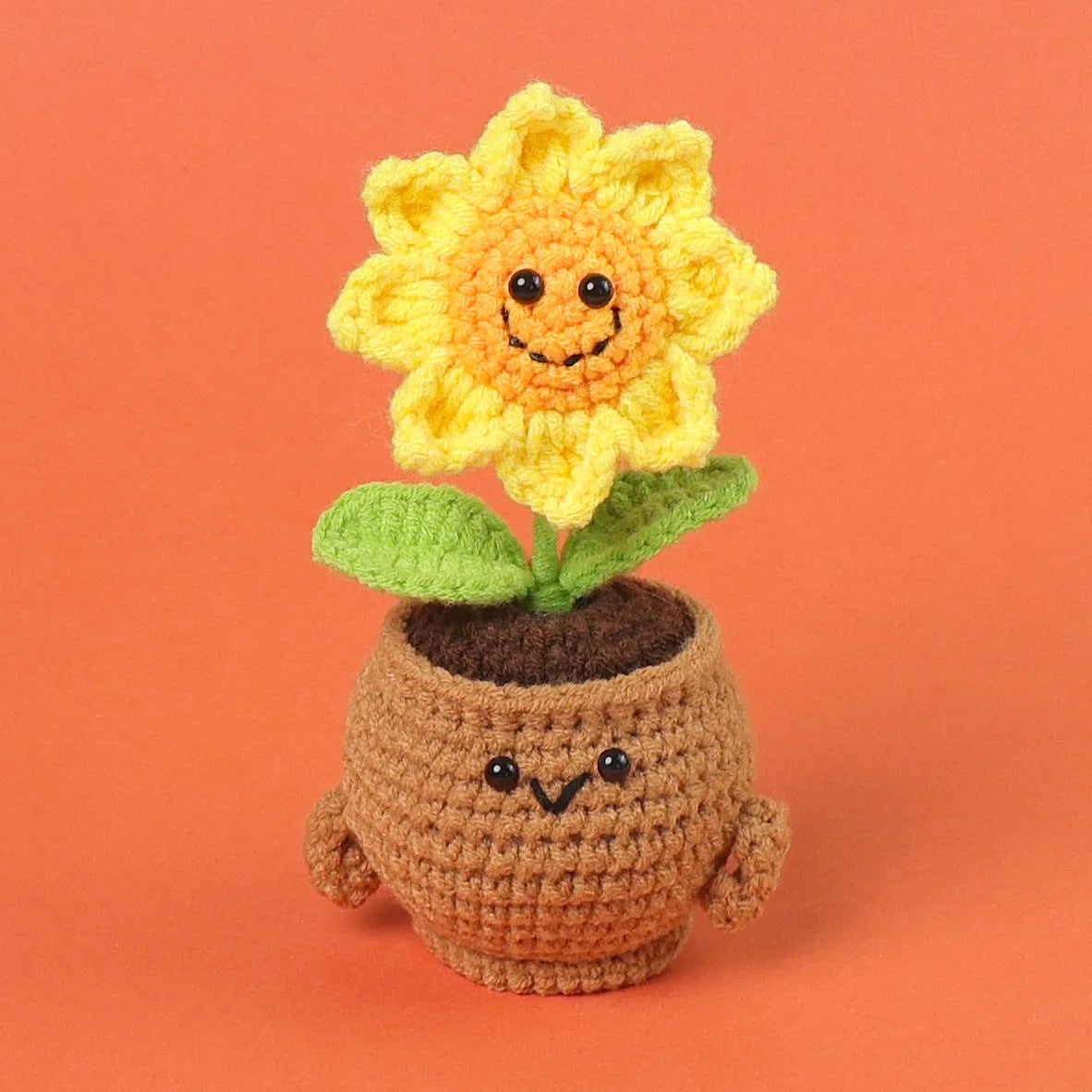 Handmade crochet sunflower desk companion with a smiling face growing out of a pot