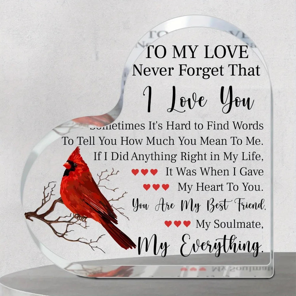 A clear heart-shaped acrylic plaque engraved with a red bird design and the message I love you sometimes it's hard to find wo