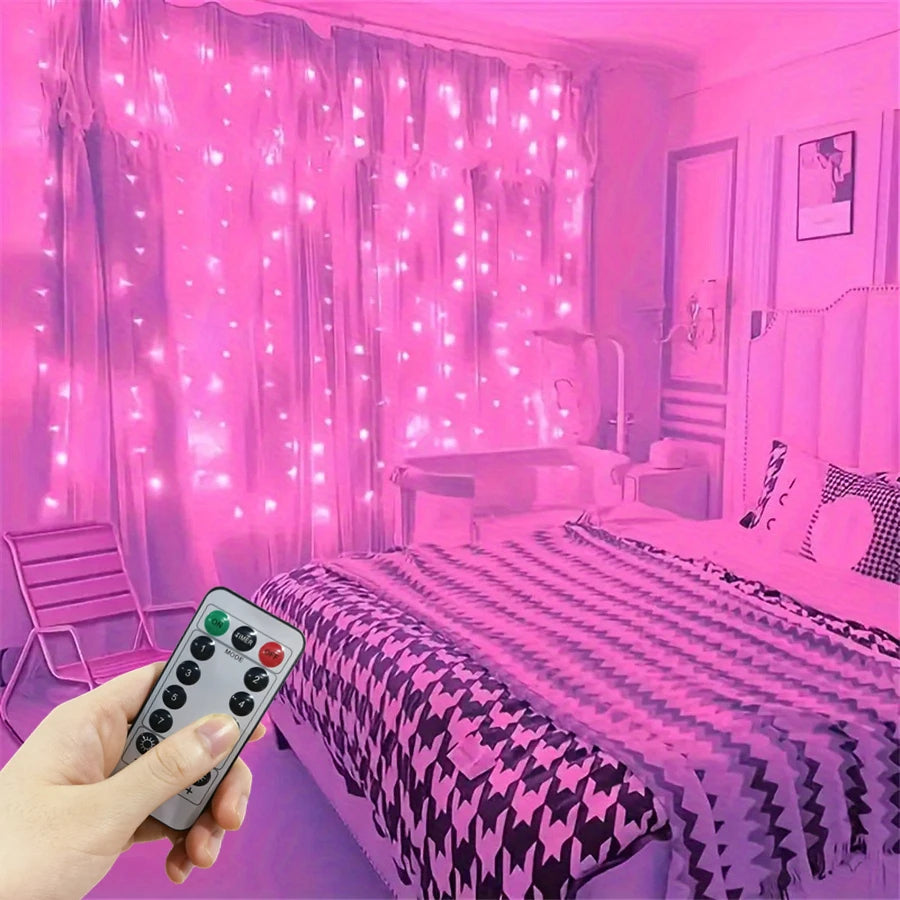 A hand holds a remote control near pink LED curtain string lights illuminating a bedroom.
